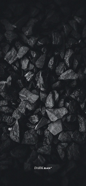 Nahaufnahme von dunkelgrauen zerklüfteten Felsen und Steinen mit tiefen Schatten für eine starke Textur.