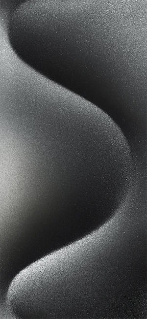 A vertical abstract image featuring a grainy, sand-like texture in shades of black and charcoal, forming a soft S-shaped curve with elegant lighting and shadows.