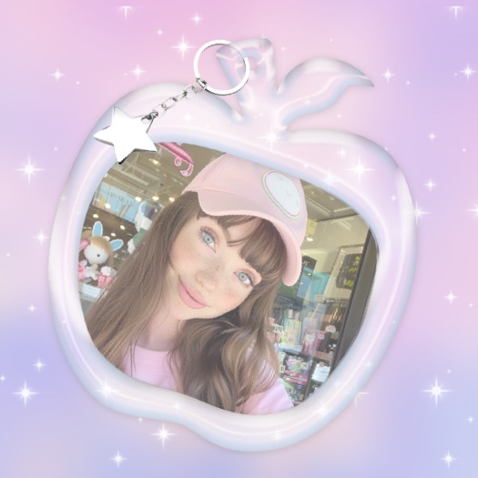 Un modèle de montage photo à une seule photo représentant un porte-clés en forme de pomme blanche brillante avec une breloque en forme d'étoile sur un fond dégradé violet scintillant.