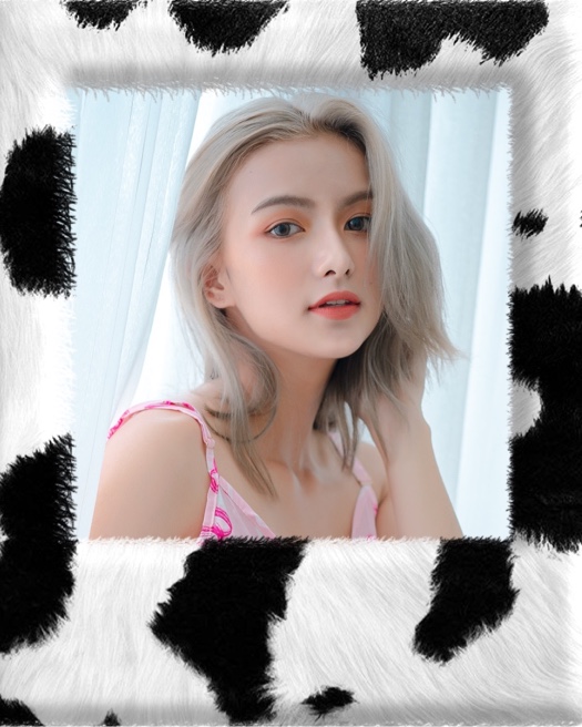 A woman portrait inside a fuzzy black and white cow print border in a Y2K aesthetic collage.
